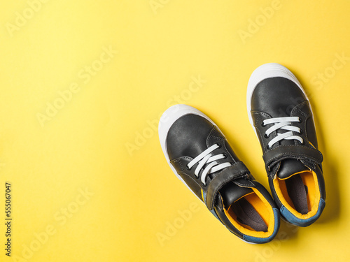 Gray and yellow sneakers on yellow background