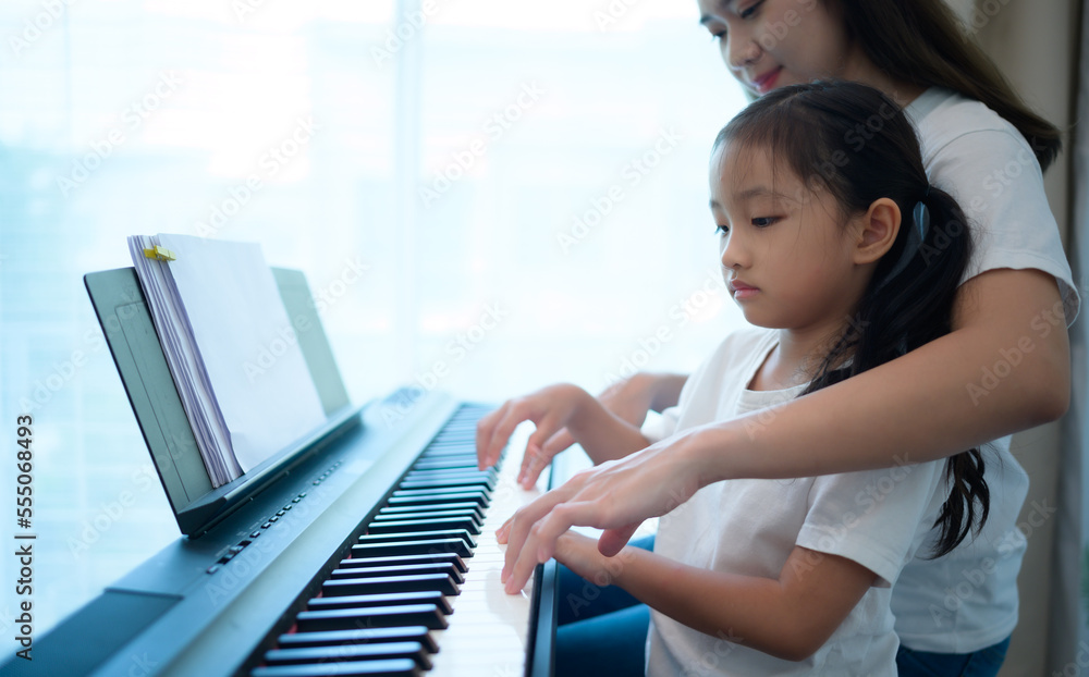 Fototapeta premium Family vacation, other helping daughter practice in her piano lessons