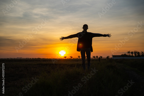 Asia Girl Stand in Feild, silhouette of a person in the sunset