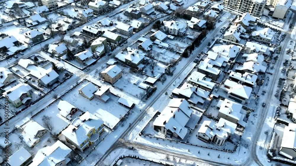 Townhouse in winter snow. Houses in Residential community in snowscape. Houses in Town after winter snowstorm. Snow covered rooftops of cottages, townhouses in winter time, Aerial view. Townhouse in winter snow. Houses in Residential community in snowscape. Houses in Town after winter snowstorm. Snow covered rooftops of cottages, townhouses in winter time, Aerial view.