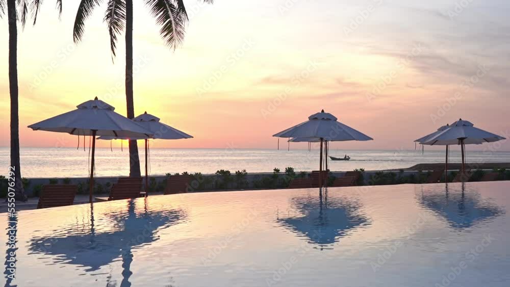 Tropical Sunset in Luxury Resort, Sky and Parasols Mirror Reflection on Pool Water Tropical Sunset in Luxury Resort, Sky and Parasols Mirror Reflection on Pool Water