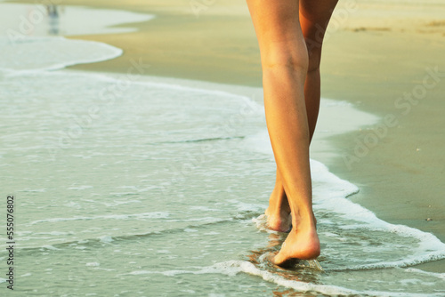 Feet on the beach near the sea. 