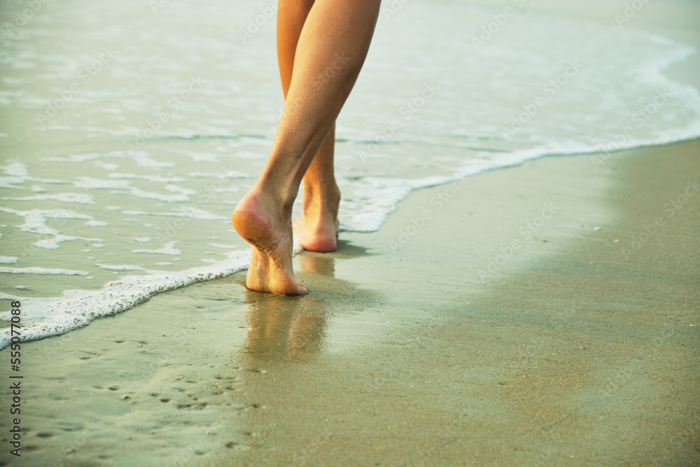 Feet on the beach near the sea.
Feet on the beach near the sea.
