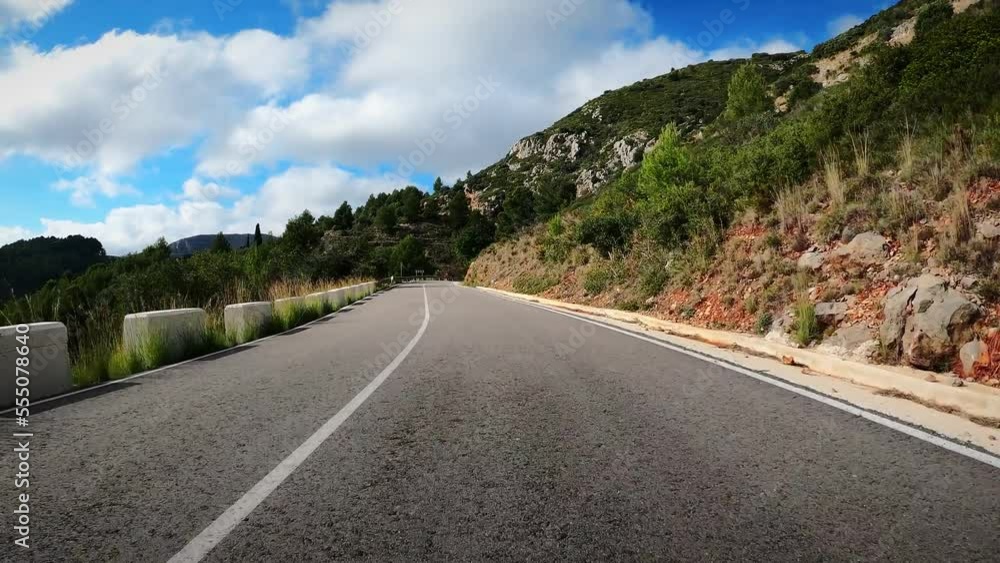 Driving on empty asphalt road through hills and mountains. Road trip. Car travel Driving on empty asphalt road through hills and mountains. Road trip. Car travel