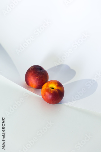 Bodegón moderno actual minimalista con frutas rojas con fondo blanco limpio con luz y sombra