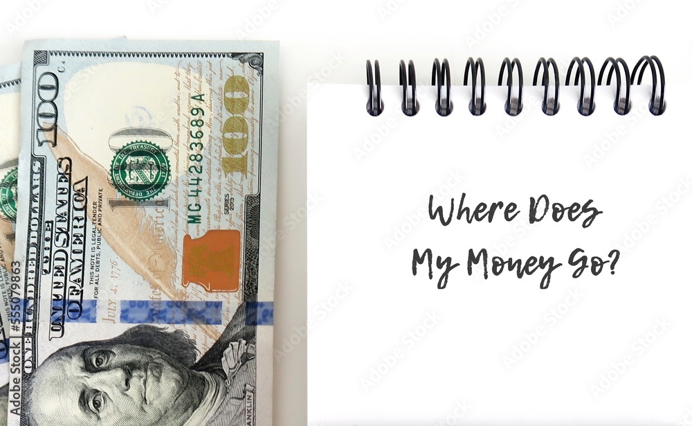 Dollars cash money with notebook and handwritten question WHERE DOES MY