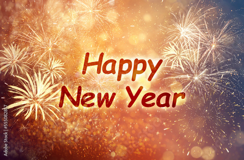 Text Happy New Year on festive background with fireworks, bokeh effect