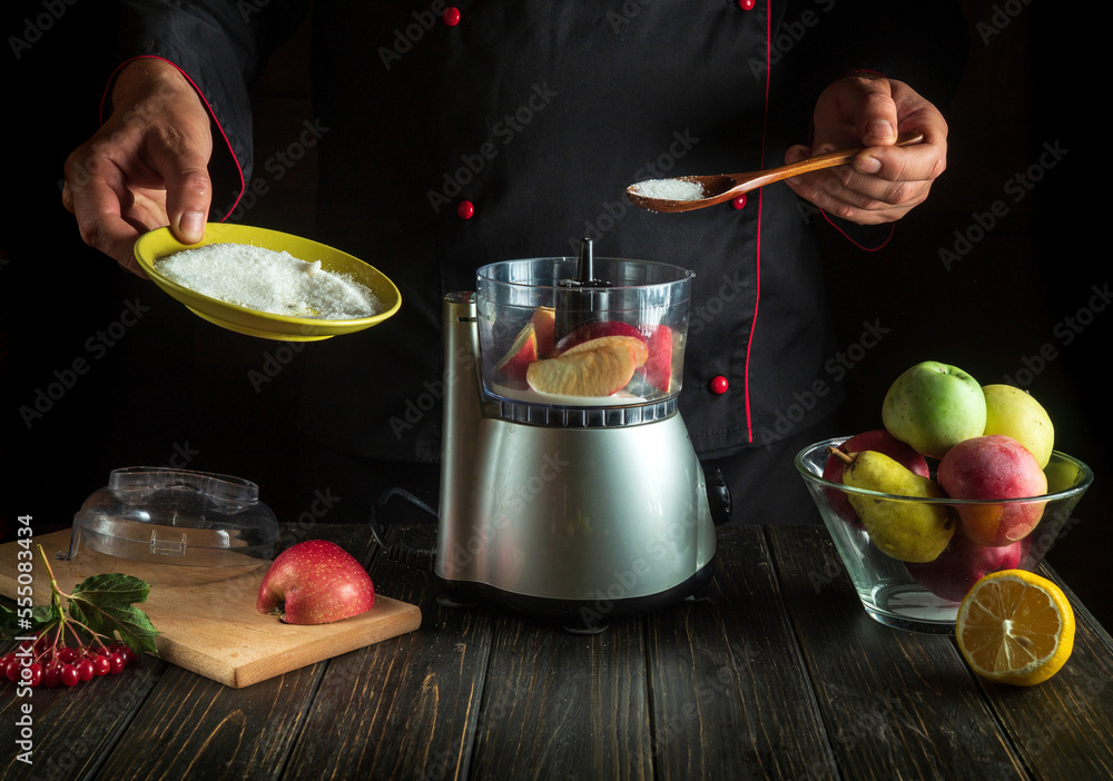 Professional chef prepares fresh apple juice in an electric blender