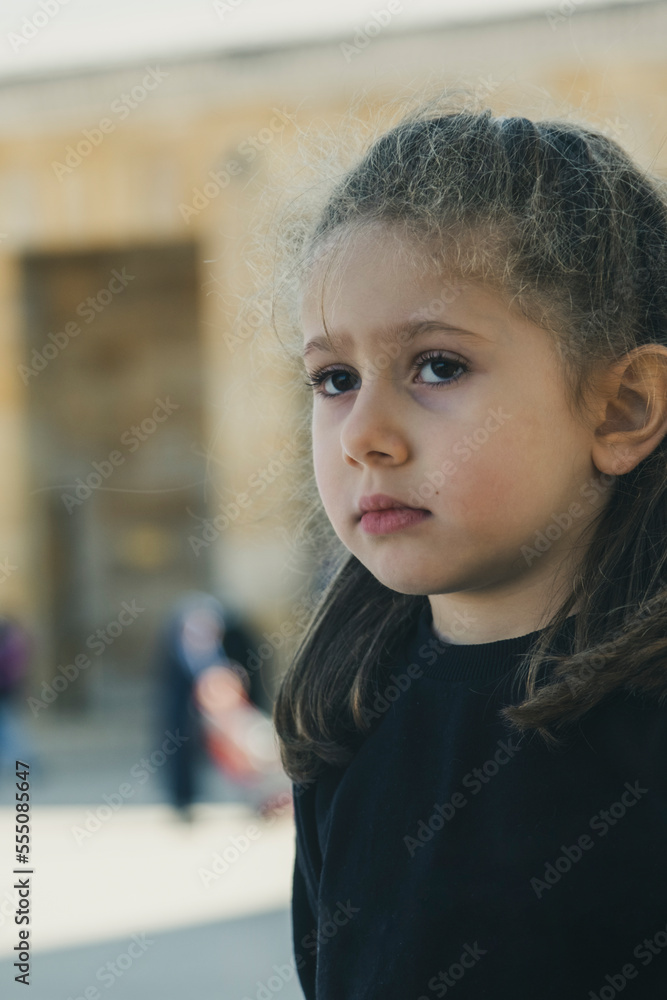 A blond little girl wearing a black sweetshirt is visiting the mausoleum in Ankara. The little girl is sad and grieving for Atatrk. Selective Focus Girls Face. A blond little girl wearing a black sweetshirt is visiting the mausoleum in Ankara. The little girl is sad and grieving for Atatrk. Selective Focus Girls Face.