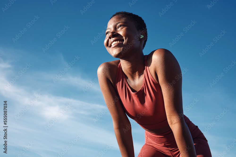 Obraz premium Fitness, black woman and happy athlete smile after running, exercise and marathon training workout. Blue sky, summer sports and run of a African runner breathing with happiness from sport outdoor