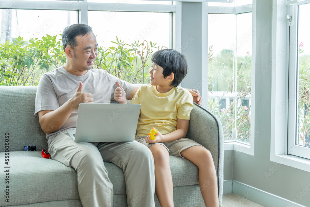 Happy Asian family male and female parents Teaching or helping with their children's homework. On holiday. Staying at home happily. Happy Asian family male and female parents Teaching or helping with their children's homework. On holiday. Staying at home happily.