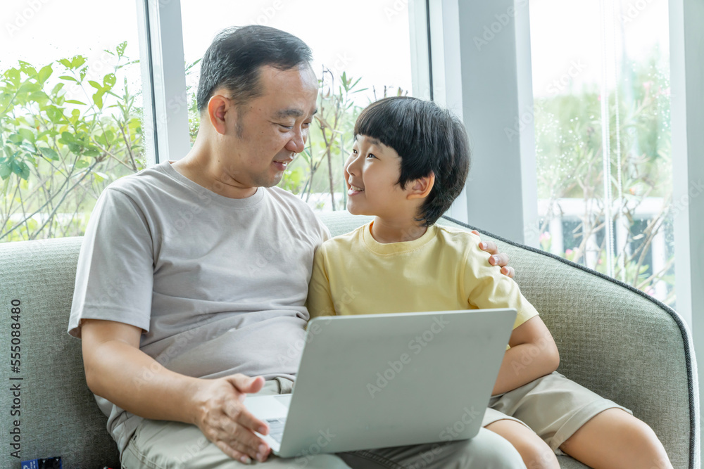 Happy Asian family male and female parents Teaching or helping with their children's homework. On holiday. Staying at home happily. Happy Asian family male and female parents Teaching or helping with their children's homework. On holiday. Staying at home happily.