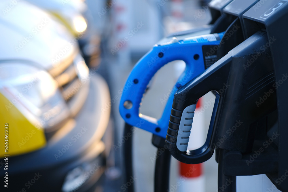 close-up of black and blue adapter with electric vehicle cables, replenish battery charging station, alternative energy development concept, electric vehicle production, electric energy storage close-up of black and blue adapter with electric vehicle cables, replenish battery charging station, alternative energy development concept, electric vehicle production, electric energy storage