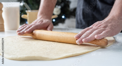 Male chef working with dough, cooking cinnamon rolls