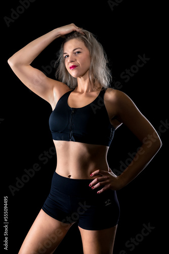portrait of beautiful young fitness woman in studio with black background © edojob