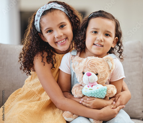 Foto Family, children hug and portrait of girls on sofa in living room while holding teddy bear