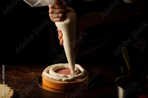 applying cream with a pastry bag to a biscuit
