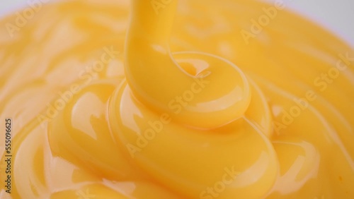 Pour yellow cheese sauce close up