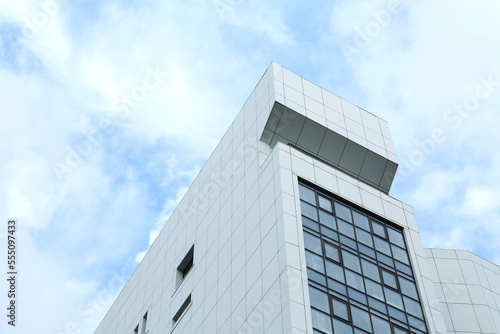 Modern office building against sky with clouds