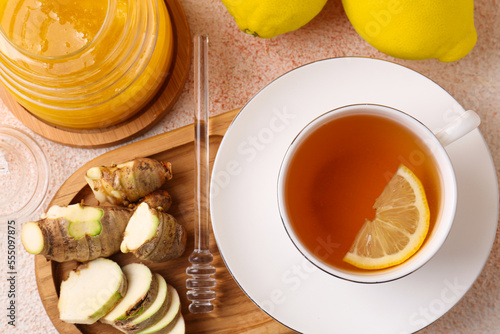 Tea, honey, lemon and ginger on beige textured table, flat lay