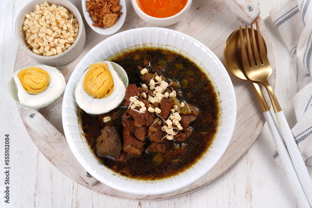 Rawon is Beef Black Soup Originally from East Java, Indonesia.served with salted egg,bean sprouts,and chilli sauce 