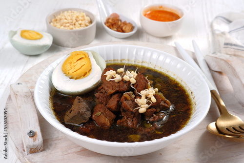 Rawon is Beef Black Soup Originally from East Java, Indonesia.served with salted egg,bean sprouts,and chilli sauce 