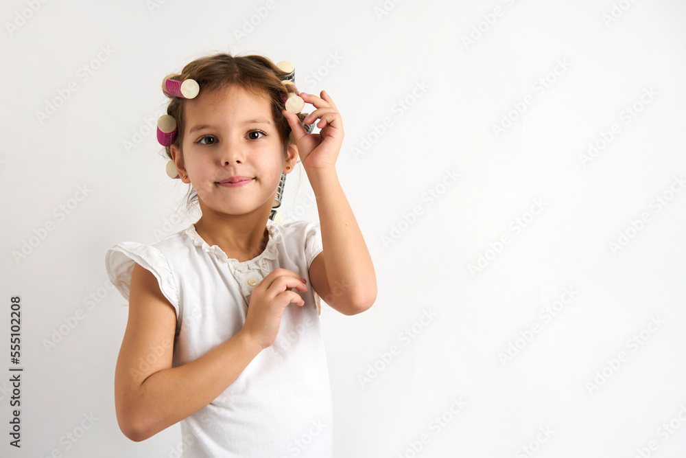 Little girl with curlers on white background Little girl with curlers on white background