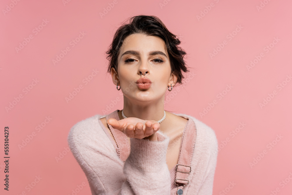 pretty brunette woman in cozy cardigan sending air kiss and looking at camera isolated on pink pretty brunette woman in cozy cardigan sending air kiss and looking at camera isolated on pink