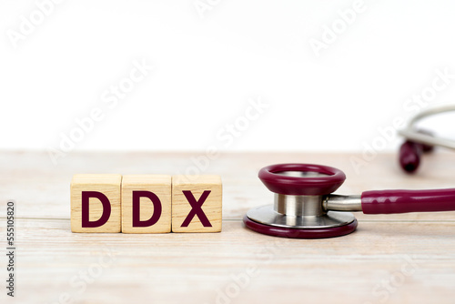 Word DDX (Differential diagnosis ) on wooden blocks and stethoscope on white background. Medical, health care. Health insurance. clinic and medical busines.   photo