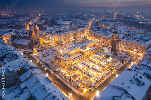 Obraz na płótnie Snow covered old town in Krakow with a view of the Christmas Market photographed in the blue hour. w salonie