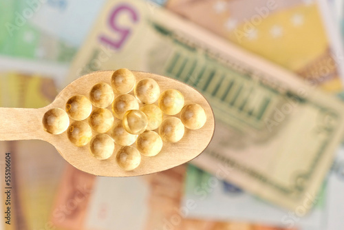 Pills in Wood Spoon on Paper Currency Background. Capsules, Vitamin with Money Cash. Expensive Drugs. Medical or Pharmacy Business, Finance Concept. Cost of Healthy Life. Medicine Price Backdrop.