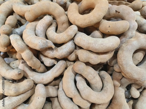 Image of tamarind pods piled up on the floor waiting to be sold