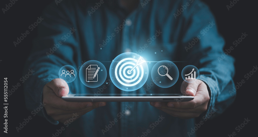Businessman holding tablet with dartboard for setup business objective target and goal concept , Technology and innovation theme. - obrazy, fototapety, plakaty 