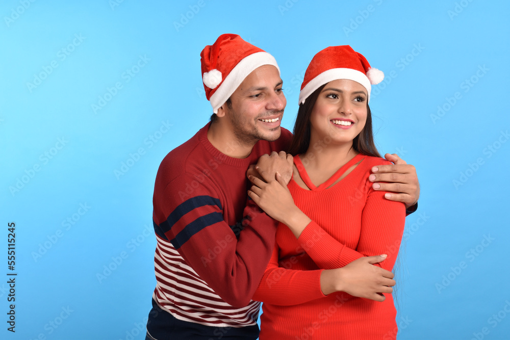 Happy Young couple wearing santa hats Happy Young couple wearing santa hats