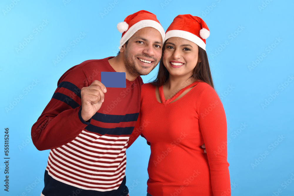 happy couple in santa hats and showing credit card happy couple in santa hats and showing credit card