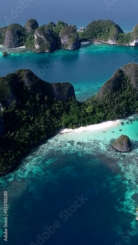 Vertical video of Aerial shot of tropical islands, turquoise water and shallow coral reef