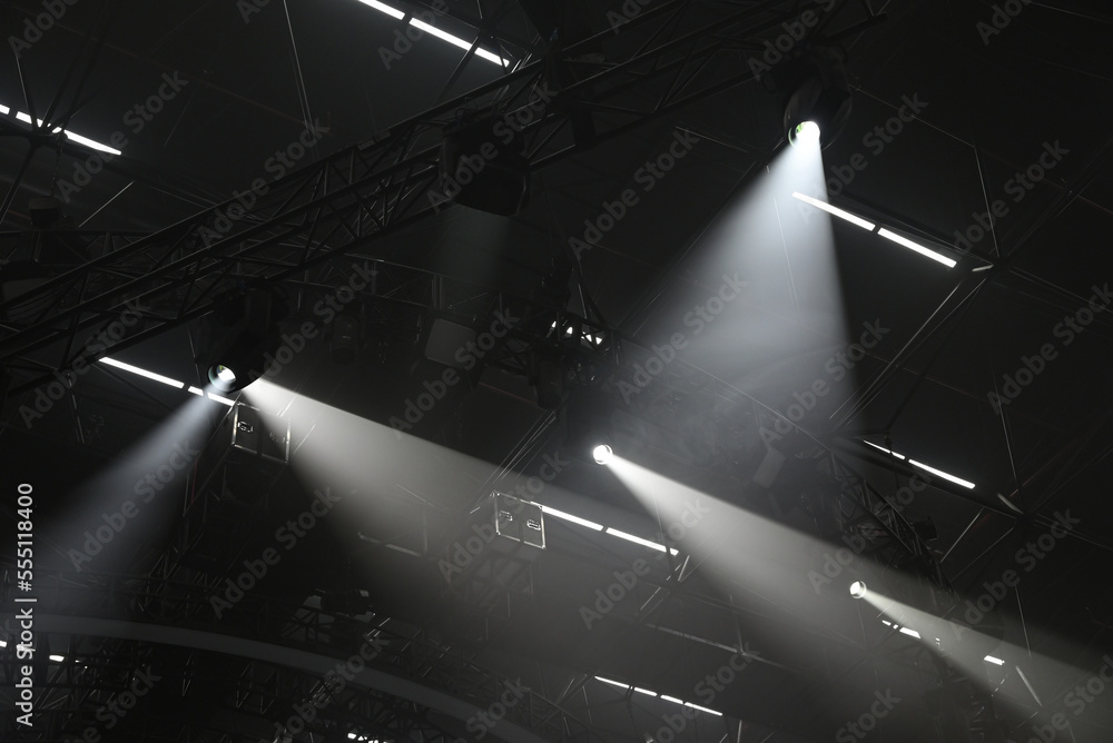 Beams of light from professional lighting equipment. Light trusses, hangar ceiling