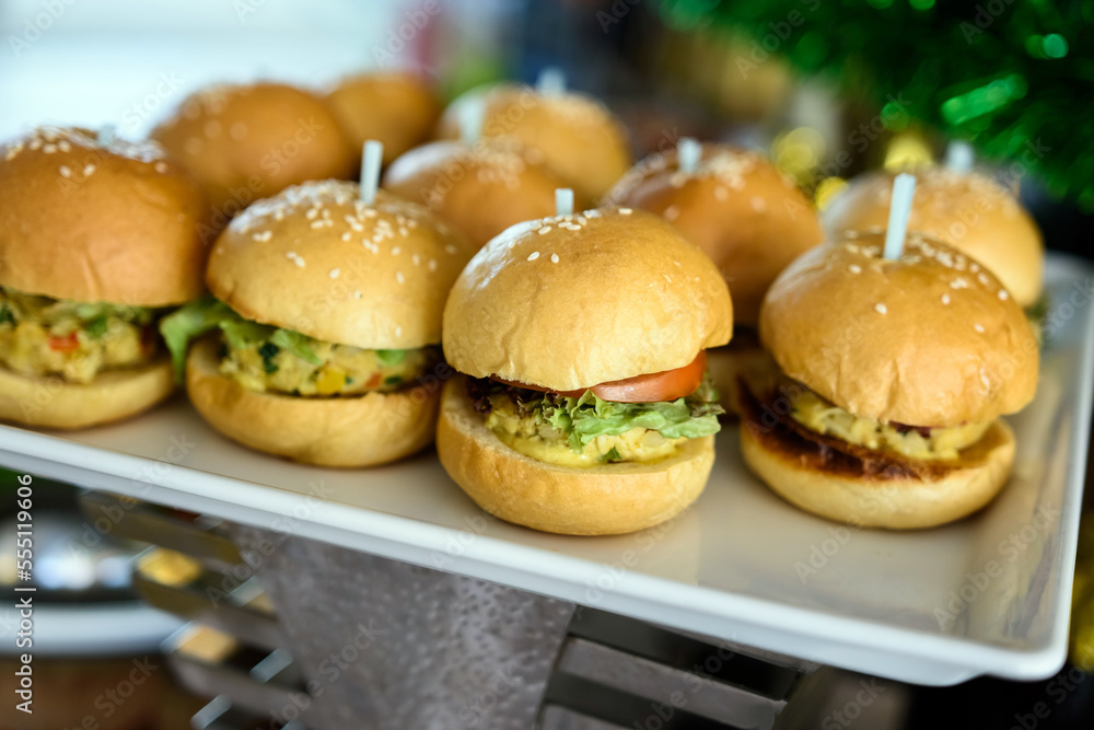 Close-up of appetizer snacks mini burgers on a white plate Close-up of appetizer snacks mini burgers on a white plate
