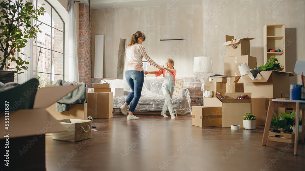 Happy Mother and Daughter Moving Into their New Cozy Home. Cheerful Young Family, Happy Girls Have Fun, Dance, Hug in the Middle of Apartment. Living Room Has Unpacked Cardboard Boxes, Furniture Happy Mother and Daughter Moving Into their New Cozy Home. Cheerful Young Family, Happy Girls Have Fun, Dance, Hug in the Middle of Apartment. Living Room Has Unpacked Cardboard Boxes, Furniture