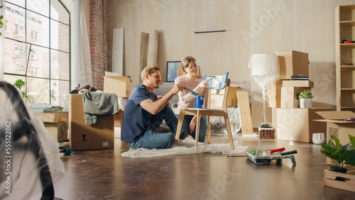 Family Moving in and Home Renovations: Couple in Love Painting Furniture Chair for Cozy Home. Boyfriend and Girlfriend Make Apartment Comfortable with Art, Color. Smiles and Happiness.