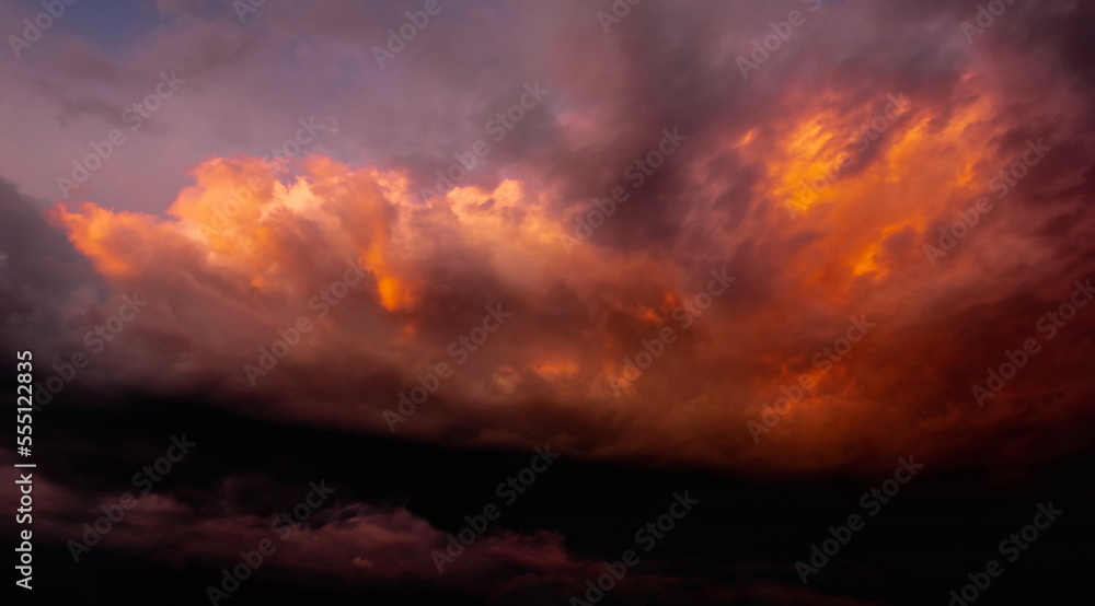  colorful dramatic sky with clouds, smoking cumulonimbus clouds reflect the golden light of the dawn sun.