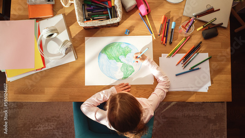 Top View  Little Girl Drawing Our Beautiful Planet Earth. Very Talented Child Having Fun at Home  Imagining Our Home Planet as a Happy Place with Clean  Sustainable Living. Cozy Sunny Day.