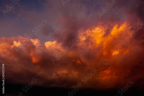  colorful dramatic sky with clouds, smoking cumulonimbus clouds reflect the golden light of the dawn sun.