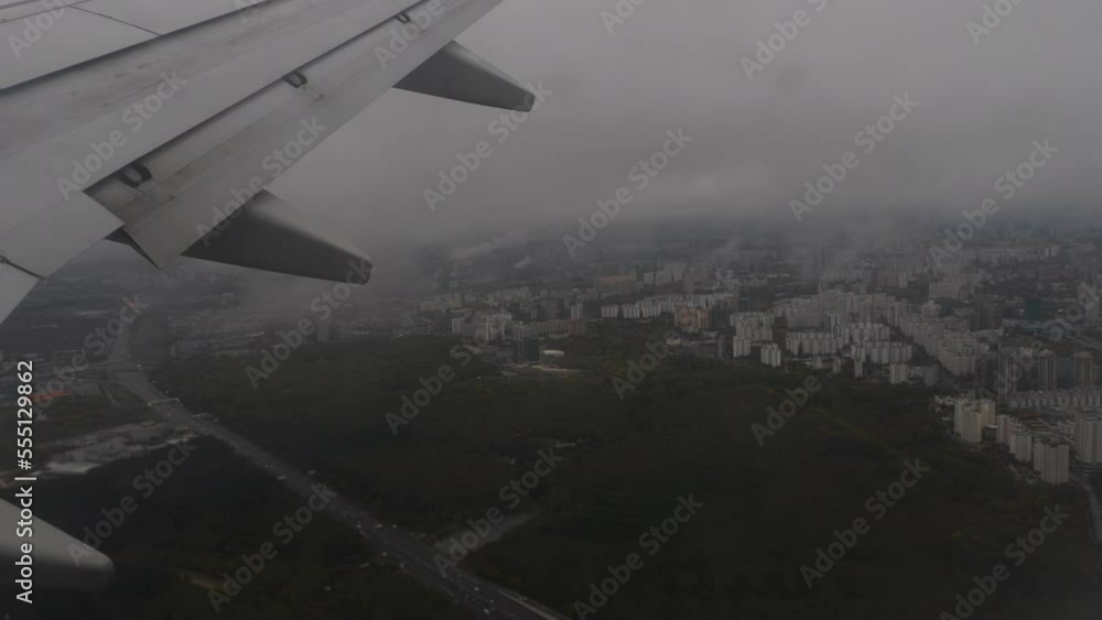 Airplane landing, clouds from the porthole. Airplane fly over city. First-person shots from the porthole while descending Airplane landing, clouds from the porthole. Airplane fly over city. First-person shots from the porthole while descending