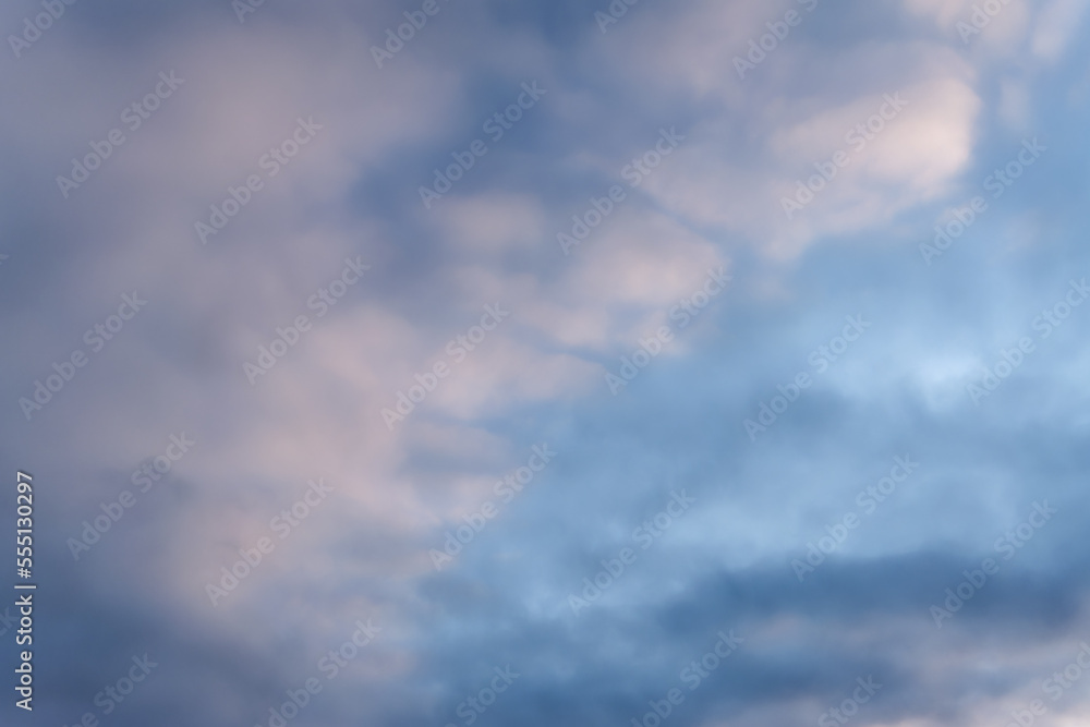 Fototapeta premium Summer evening sky in the picturesque clouds, lit by the rays of the setting sun.