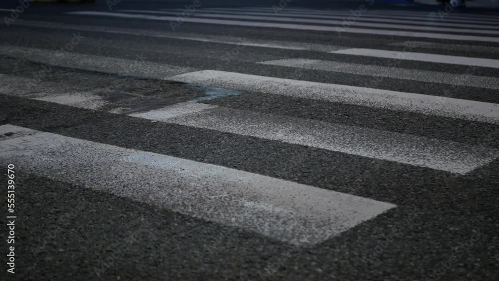 street while people pedestrian crossing the street in night time, close up to floor with people crossing road street while people pedestrian crossing the street in night time, close up to floor with people crossing road