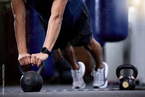 Exercise, kettlebell and strong hands man doing gym workout with a fitness watch during muscle training as bodybuilder with metal weights. Athlete with smartwatch to train for power and health goals