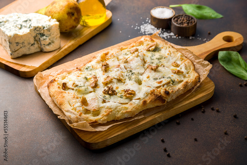 Bild auf Leinwand pizza with pear and Gorgonzola on Roman dough, pinsa on dark brown table
