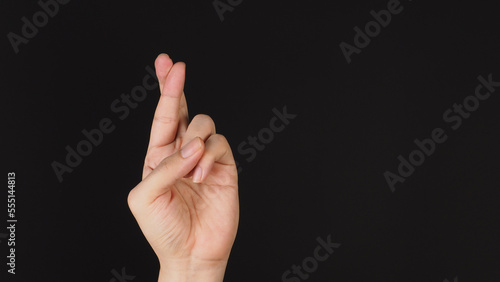 Good luck hand sign on black background.