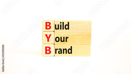BYB build your brand symbol. Concept words BYB build your brand on wooden blocks on a beautiful white table white background. Business and BYB build your brand concept. Copy space.